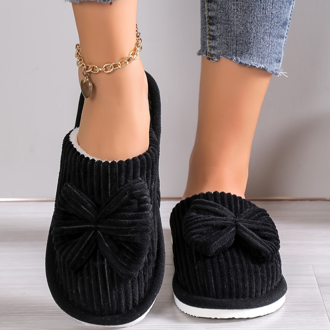 Women's slip-on winter slippers with cozy lining, bow detail, soft textured surface for indoor comfort