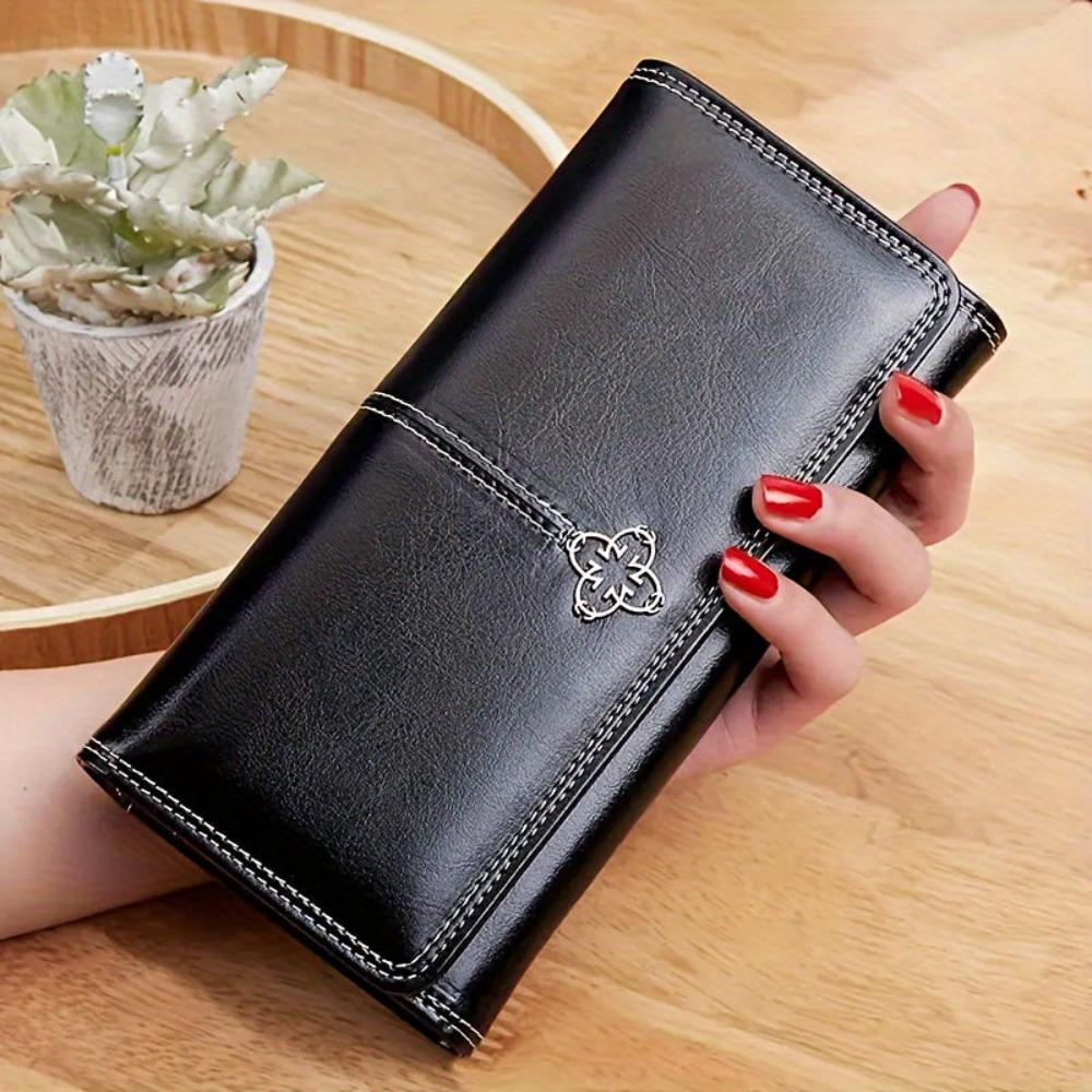 Men's black vegan leather bifold wallet with contrast stitching and decorative metal emblem