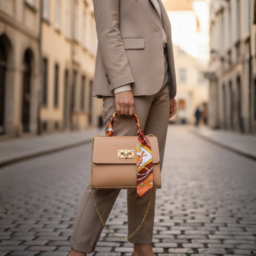 Beige faux leather tote bag with golden chain handle and colorful scarf accent for women