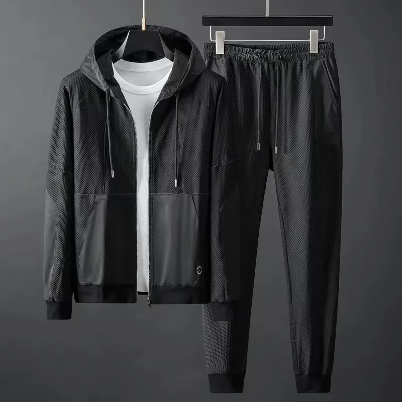 Black techwear tracksuit set with breathable mesh hooded jacket and matte tonal paneling for urban athletes