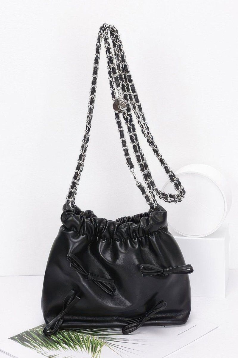 Black faux leather bucket crossbody bag with ribbon embellishment, gold chain strap, cinched closure