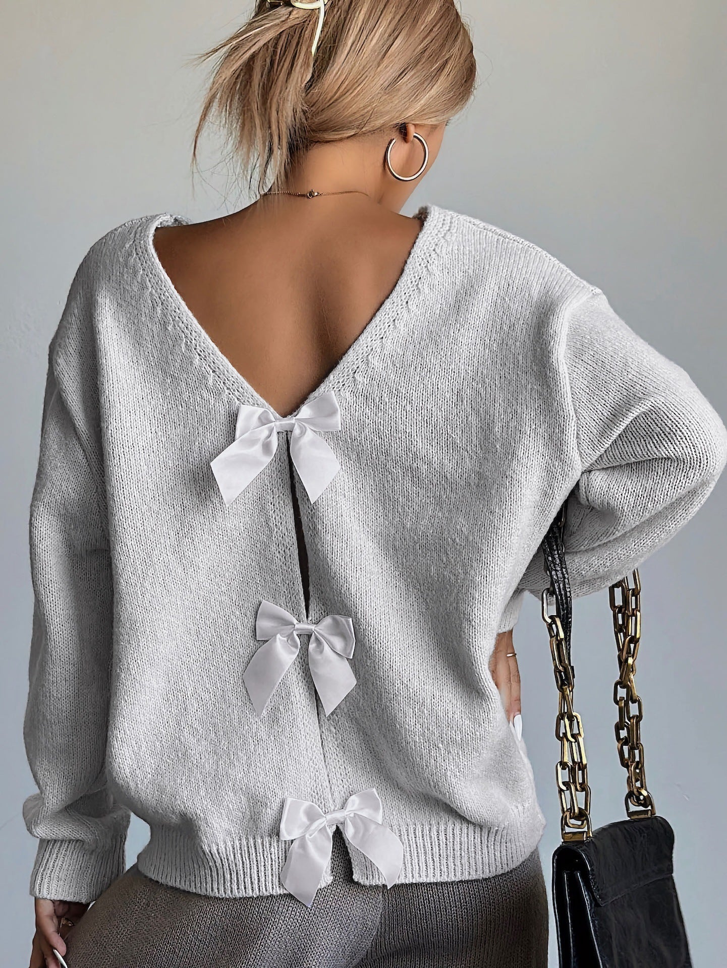 Women's knit sweater with back cutout and bow detail, elegant feminine style for everyday comfort