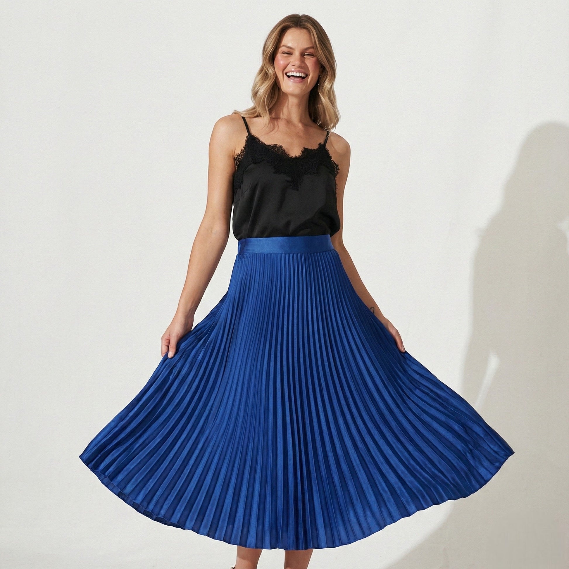 Women's high-waisted pleated satin skirt in neutral tone with flattering silhouette for office wear