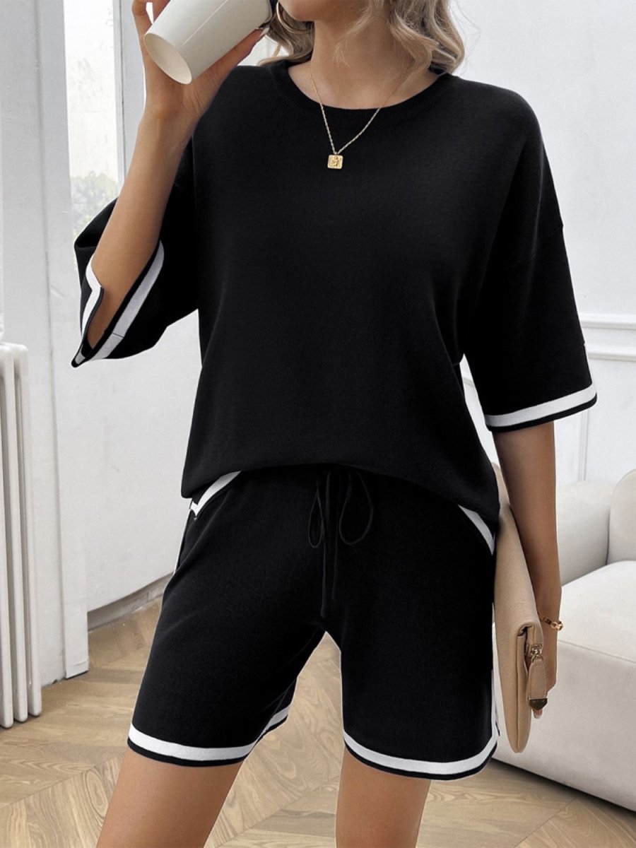Women's black loungewear set with contrast trim round neck top and matching shorts, bold casual style