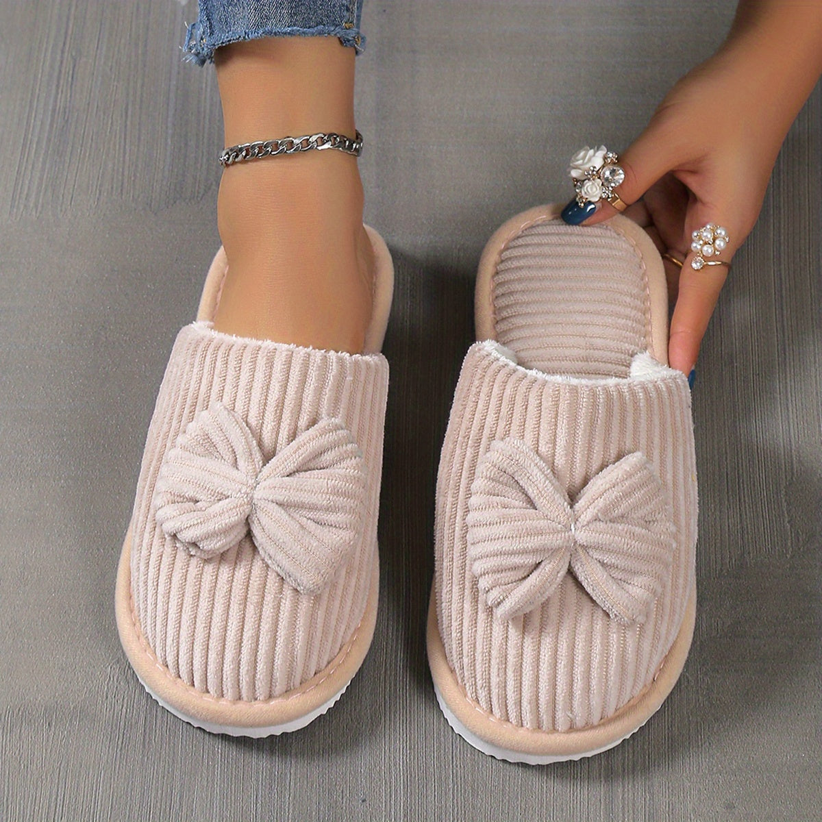 Women's slip-on winter slippers with cozy lining, bow detail, soft textured surface for indoor comfort