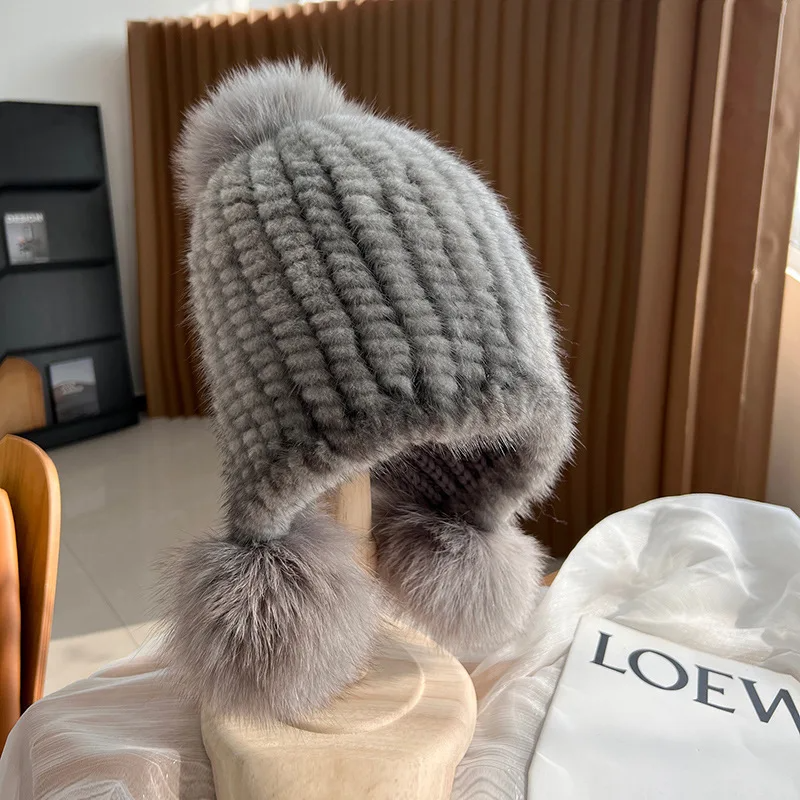 Women's warm ribbed knit fur beanie in neutral tones with plush pom poms, cozy winter style