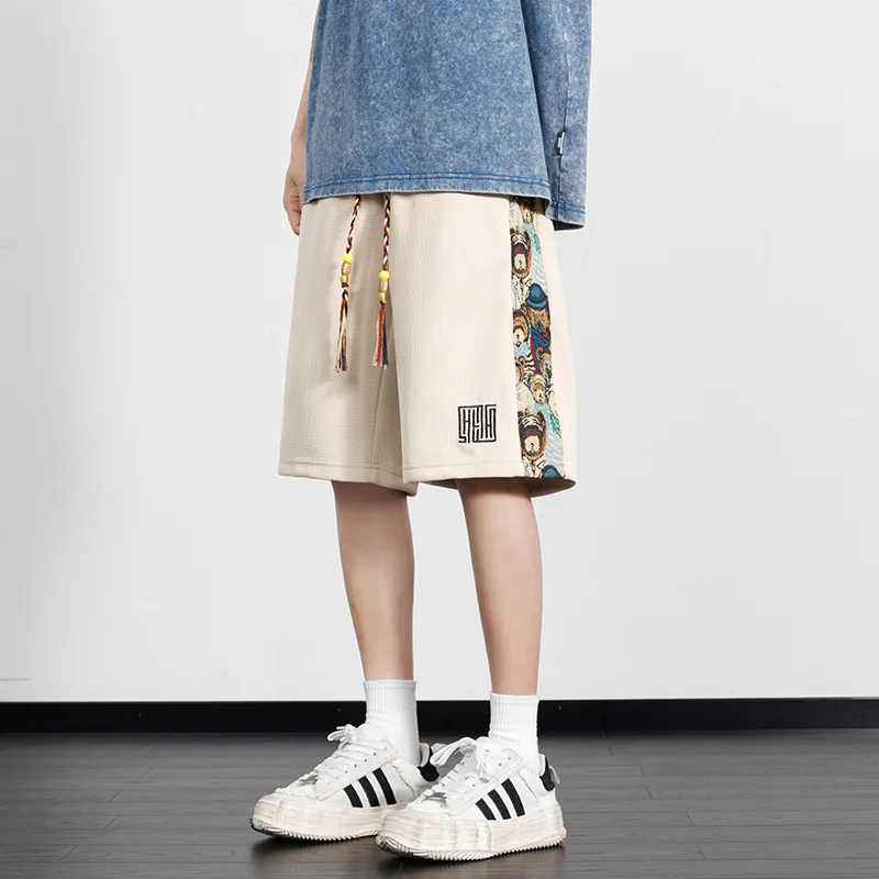 Black streetwear shorts with bold panel design, teddy bear embroidery, and oversized drawstrings in breathable cotton