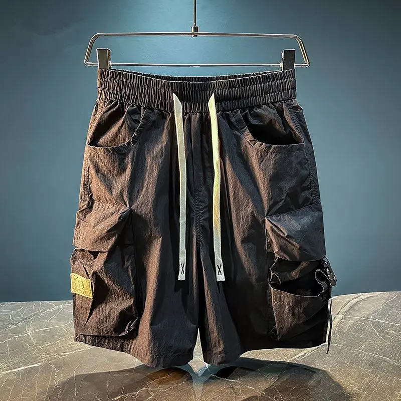 Black tactical cargo shorts with exaggerated flap pockets and tech buckle closure for urban movement