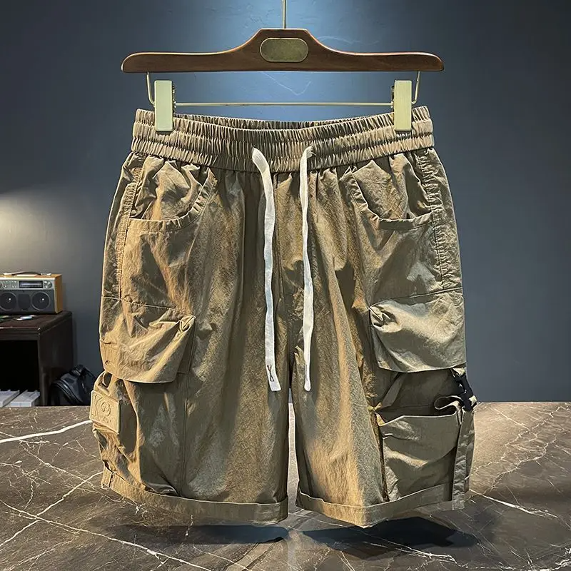 Men's black tactical cargo shorts with exaggerated flap pockets and tech buckle closure for urban explorers