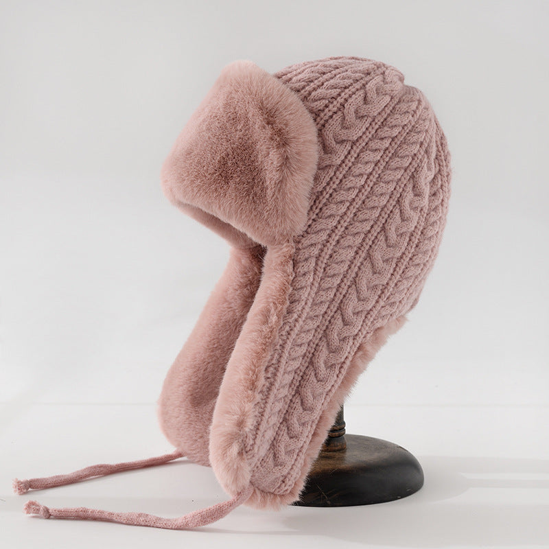 Beige cable knit trapper hat with faux fur trim ear flaps and braided tie straps for women