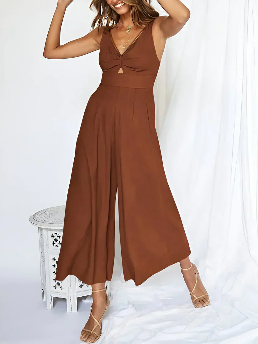 Navy blue sleeveless wide-leg jumpsuit with V-neck and high waist defining silhouette
