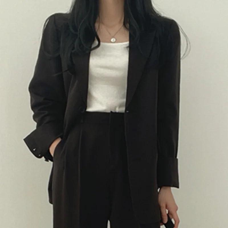 Women's tailored two-piece blazer suit in classic hue, sleek professional cut for polished officewear