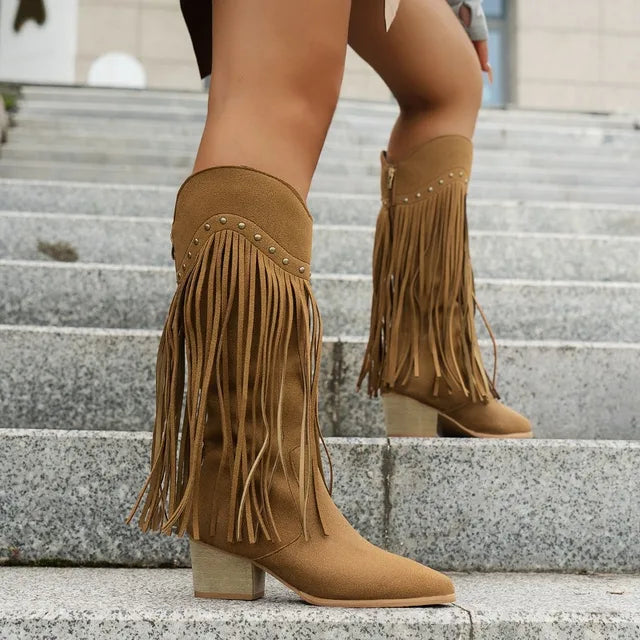 Women's tan knee-high fringe western boots with elongating silhouette and flowing fringe detail