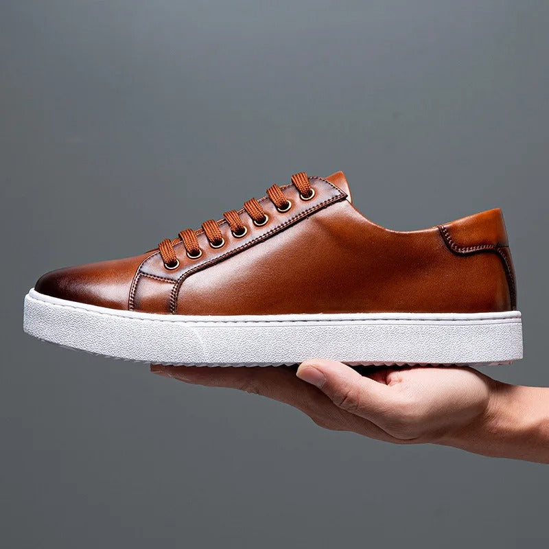 Men's low-cut urban sneakers with metal eyelets, minimalist white design, and contrasting outsole for streetwear