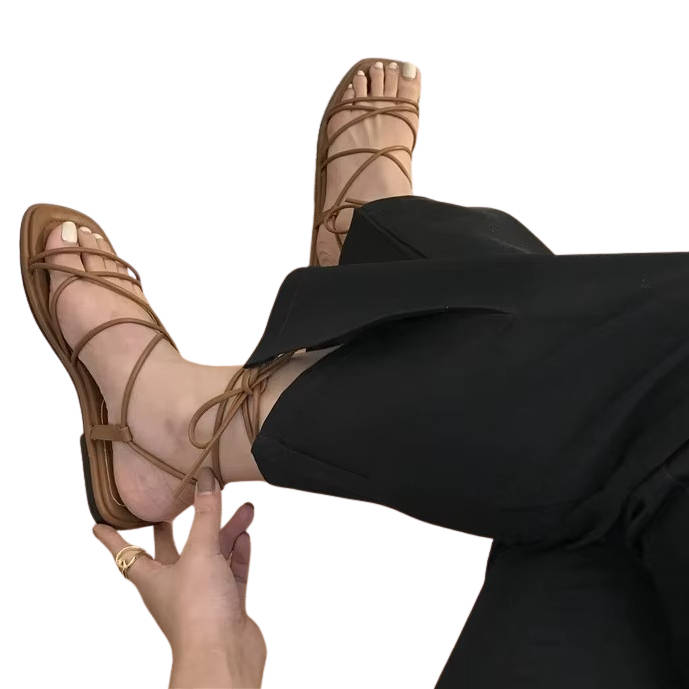 Women's strappy lace-up flat sandals with cross-strap silhouette and adjustable wrap-around ankle lacing