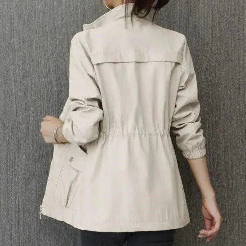 Beige lightweight trench coat with adjustable waist belt, clean silhouette, and spacious front pockets