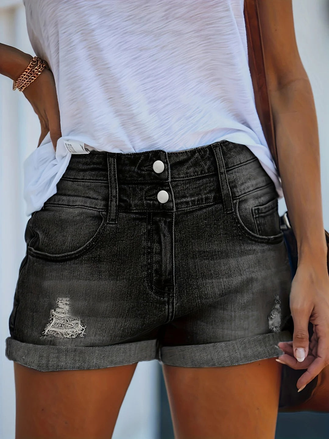 Women's slim fit distressed shorts with rolled hem and cutout detailing for a structured seasonal look