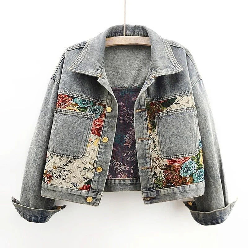 Cropped blue denim jacket with hand-painted floral motifs, relaxed artisanal silhouette