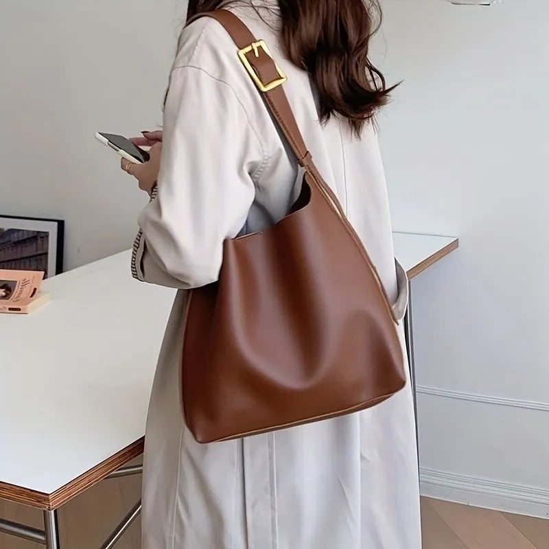 Structured trapezoidal shoulder bag minimalist design wide adjustable strap professional everyday carry