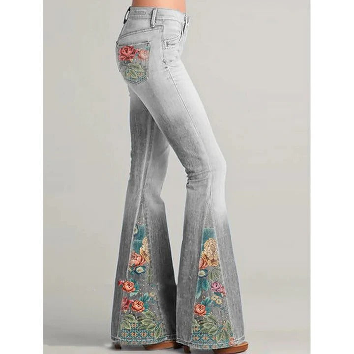 Women's vintage flare jeans in blue denim with intricate floral embroidery along pockets and legs
