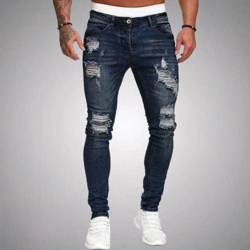 Men's slim fit ripped jeans in distressed denim with bold torn knee accents for day-to-night style
