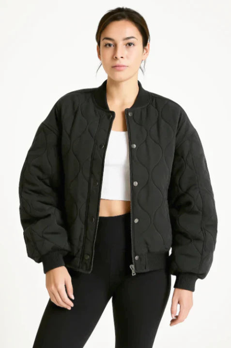 Women's oversized quilted bomber jacket in neutral tone, relaxed streetwear fit with distinctive quilted pattern