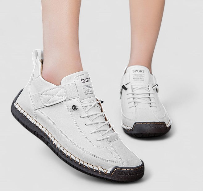 White high-top sneakers with stitched panels, lace-up front, adjustable strap, and structured urban silhouette