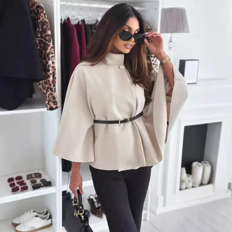 Women's black oversize poncho blouse with elegant draping and belt loop for a modern urban look