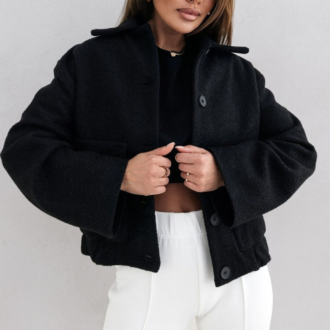 Women's oversized wool blend jacket with button closure, side pockets, and elastic hem in modern urban style
