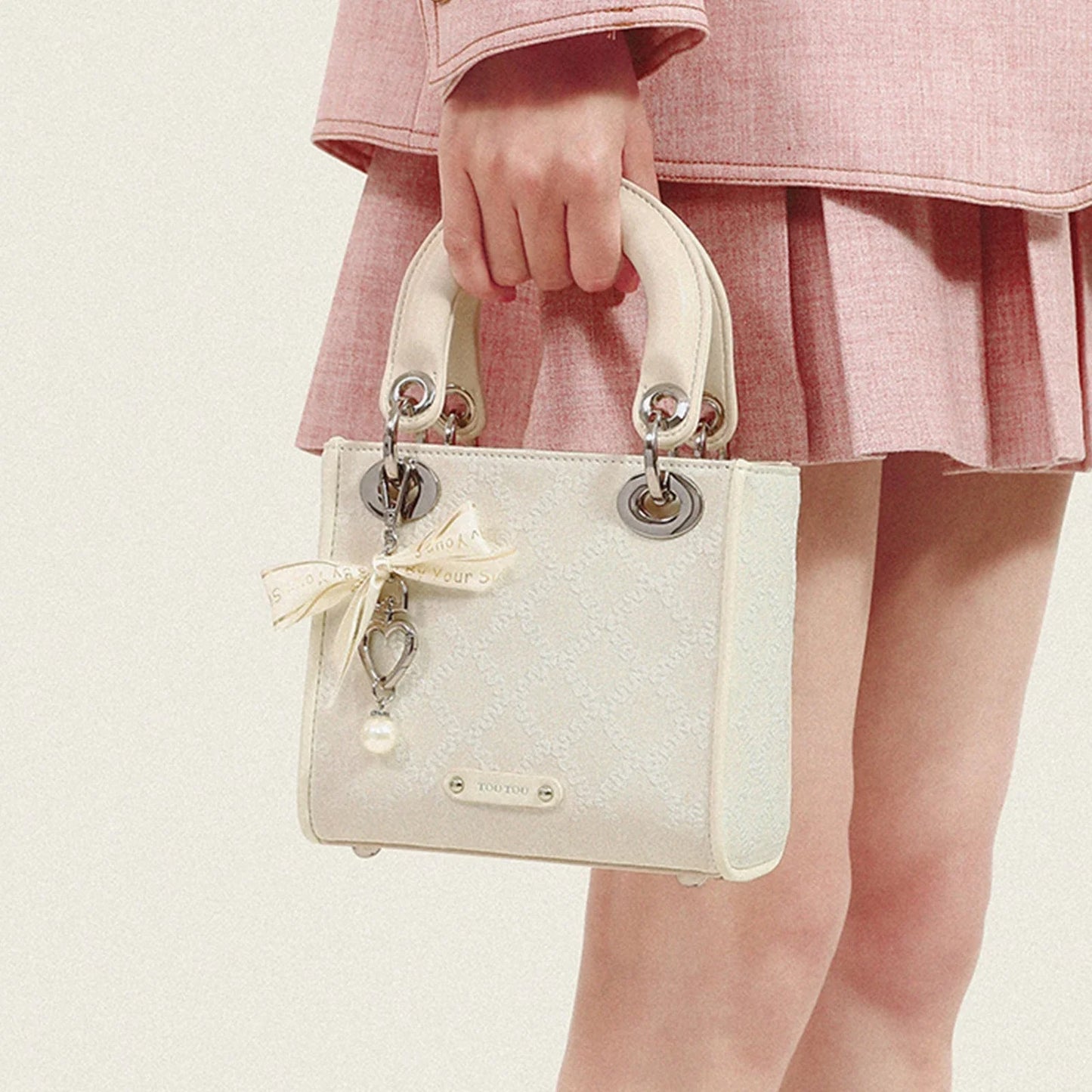 Ivory jacquard structured handbag with delicate bow and pearl charm, feminine elegant style