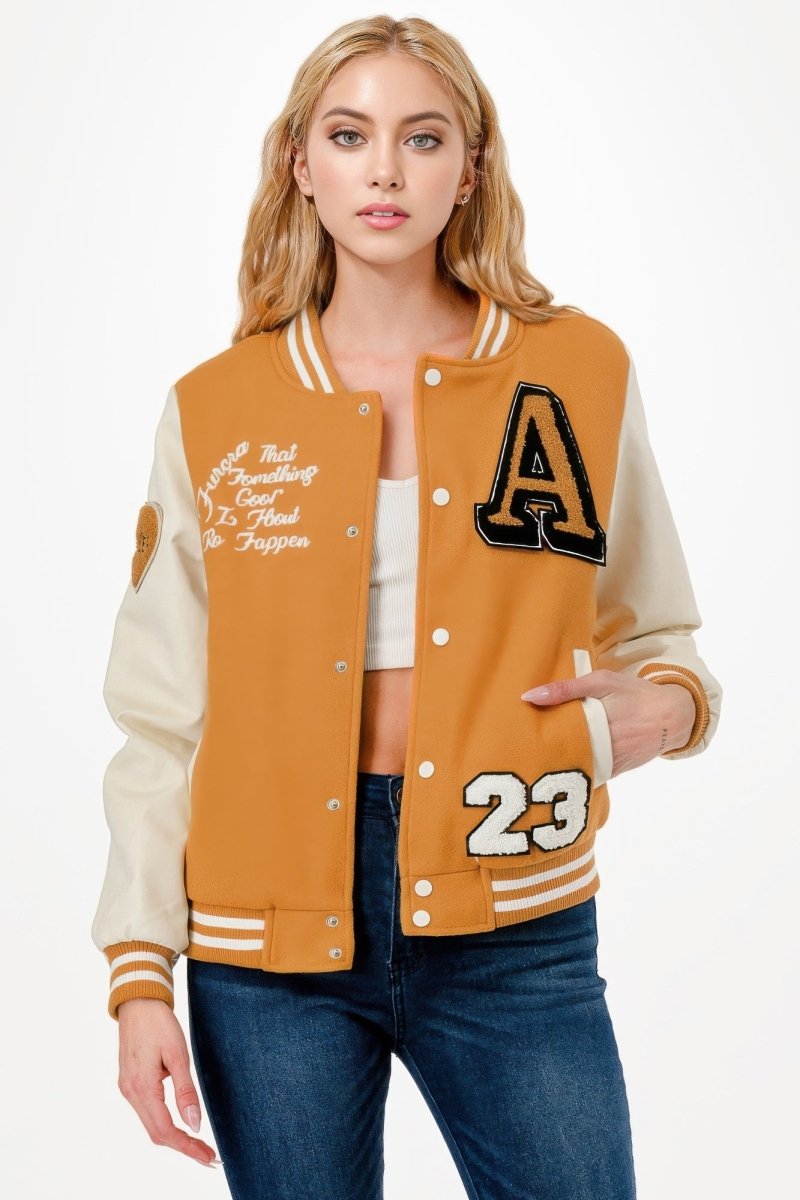Black varsity bomber jacket with embroidered patches, ribbed cuffs, and bold functional pockets