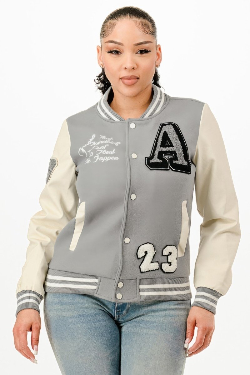 Black varsity bomber jacket with embroidered patches, streetwear cut and bold functional pockets