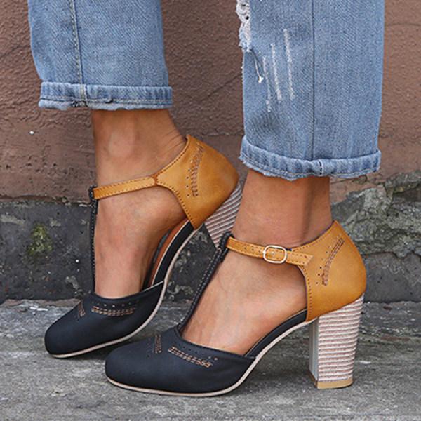 Women's black T-strap block heels with intricate brogue detailing and adjustable buckle closure