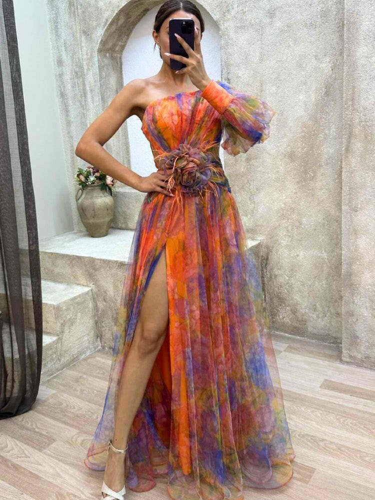 Floral maxi dress with one-shoulder neckline, flowing tulle skirt, and rosette waist detail