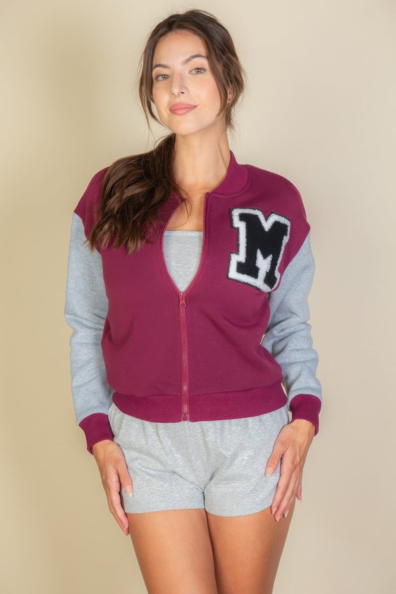 Black varsity jacket with striped trim, letter patch, relaxed collegiate fit for students and sports fans