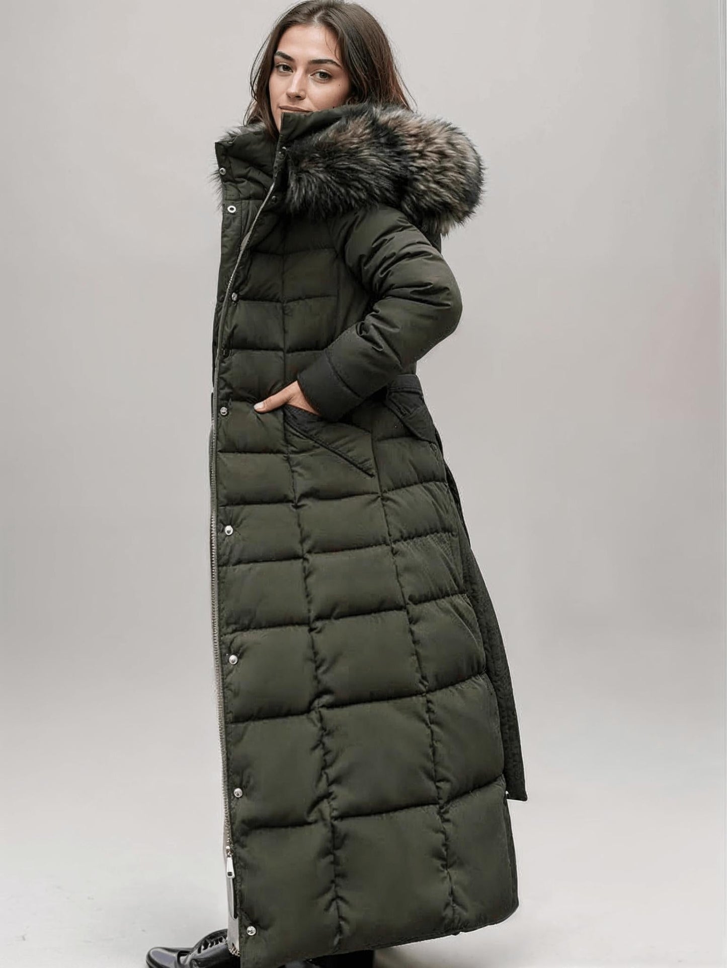 Women's long puffer jacket with belted waist, hood, and snap buttons for winter wind protection