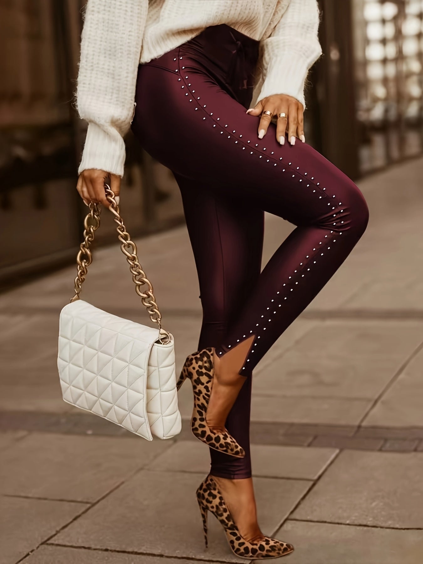 Black faux leather sculpting pants with silver studs, satin tie waist, and sleek second-skin fit