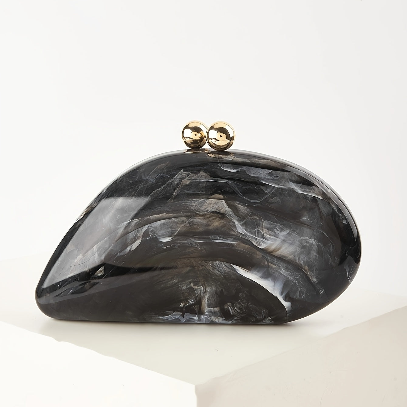Marble-finish acrylic clutch bag with gold kiss-lock clasp and detachable chain strap for evening