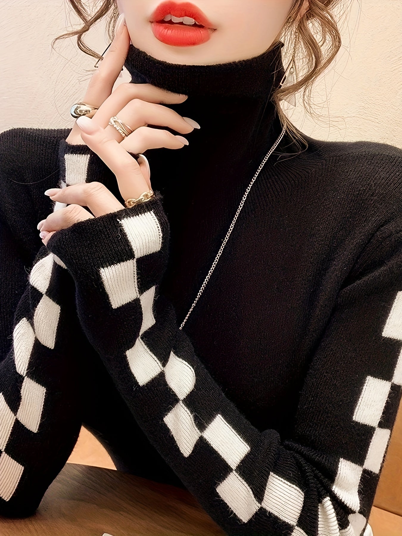 Women's cream turtleneck sweater with bold checkerboard sleeves, cotton-blend soft knit