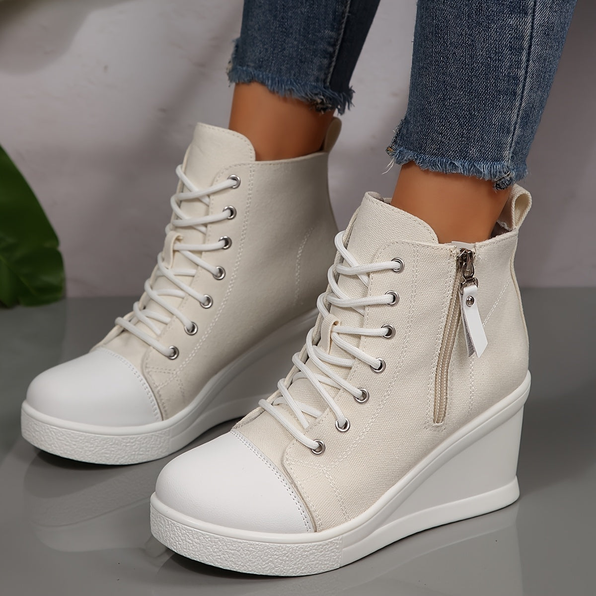 Women's white canvas wedge sneaker with side zip closure and sculpted hidden heel for urban style