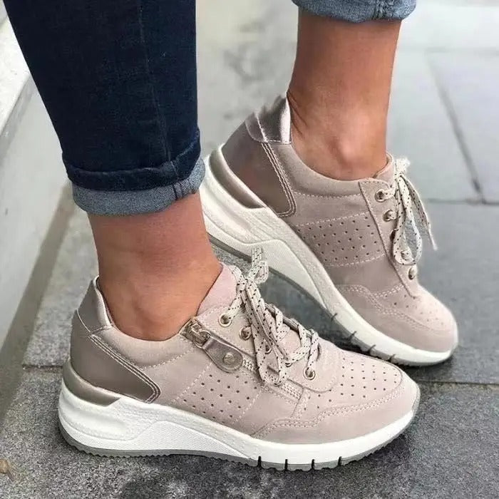 Women's white wedge sneakers with perforated panels, lace-up front, and side zip closure for easy wear