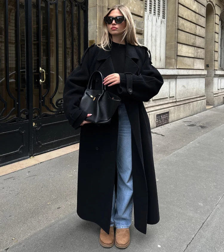 Women's longline tailored coat, classic neutral tone, structured silhouette with refined lapel and flowing length