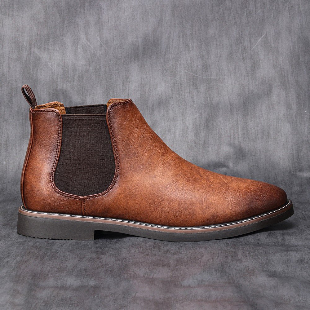 Men's black leather Chelsea boots with elastic side panels and sleek minimalist silhouette