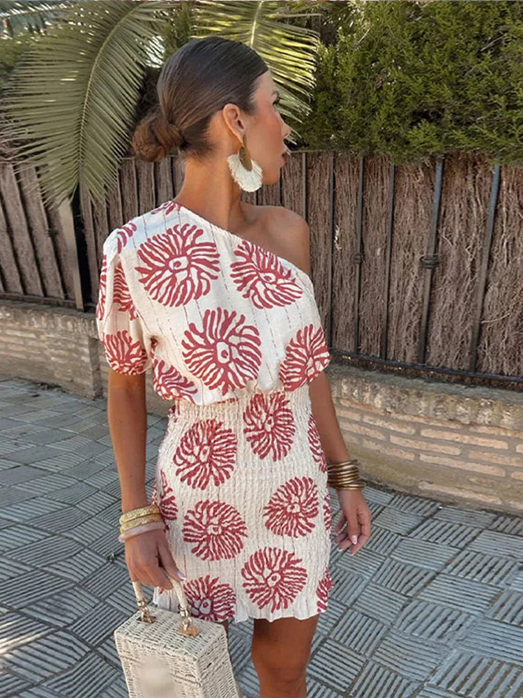 Red one-shoulder mini dress asymmetrical hem bold print relaxed blouson silhouette seaside glamour