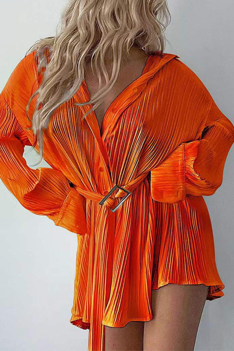 Women's pleated mini shirt dress in neutral tone with belted waist and button-down front silhouette
