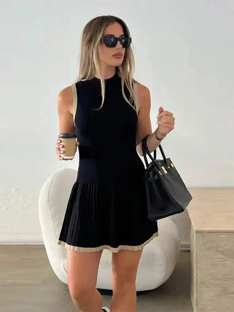 Black sleeveless pleated mini dress high neck fitted bodice flared skirt day-to-night style