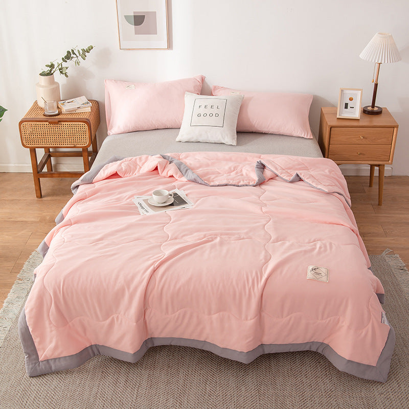 Minimalist white cotton quilt with delicate stitched pattern, lightweight breathable design for hot sleepers