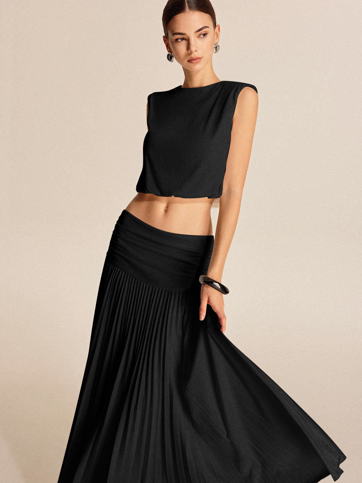 Women's pleated skirt set with shoulder pads, button detail, lightweight jersey, chic two-piece style