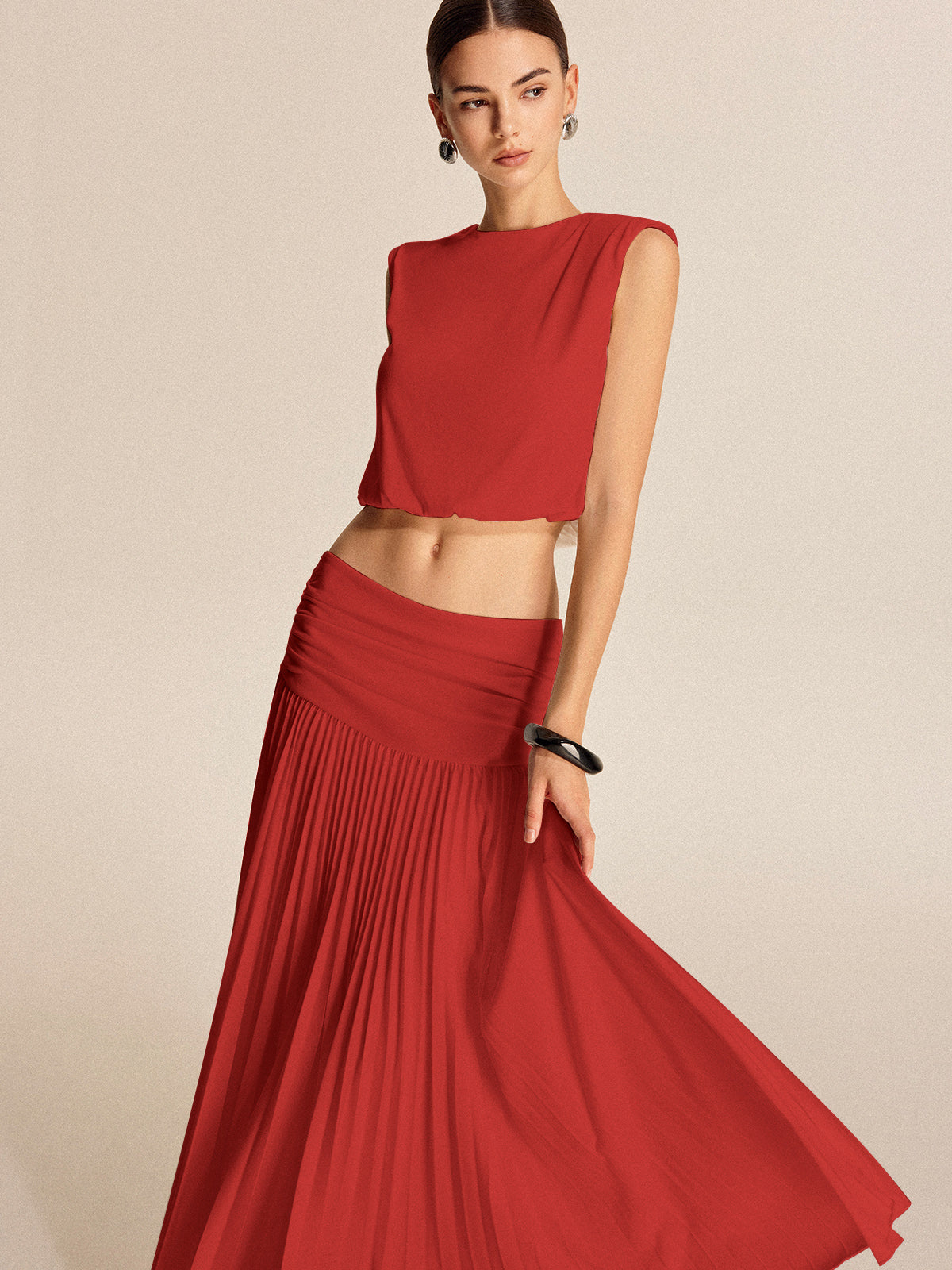 Women's pleated skirt set with shoulder pads, button detail, lightweight jersey, chic two-piece style