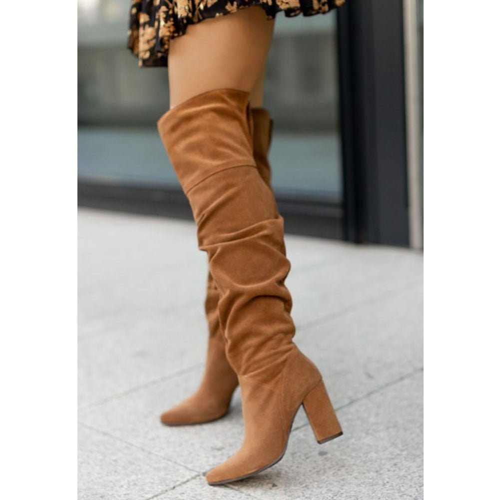 Women's black over-the-knee slouchy boots with pointed toe and chic block heel for evening glam
